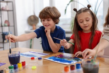 Çocuklar kapalı mekanlarda resim yapıyor. Çizim yapmayı öğrenmek