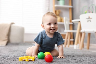 Odada oyuncaklarla oynayan şirin bir bebek.