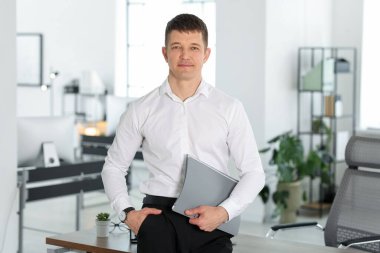 Ofisinde dosyası olan yakışıklı bir adamın portresi.