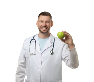Beyaz arka planda yeşil elmalı ve steteskoplu beslenme uzmanı.