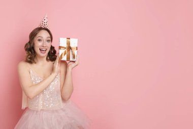 Doğum günü kutlaması. Pembe arka planda yeteneği olan bir kadın. Metin için boşluk
