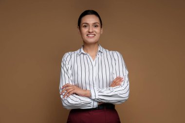 Kahverengi arka planda kendine güvenen bir iş kadını portresi