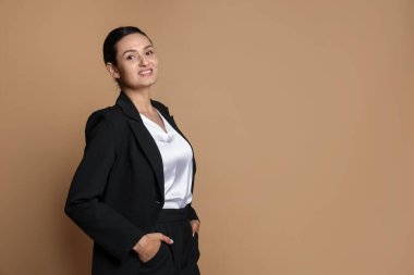 Bej arka planda takım elbiseli kendine güvenen bir iş kadını. Metin için boşluk