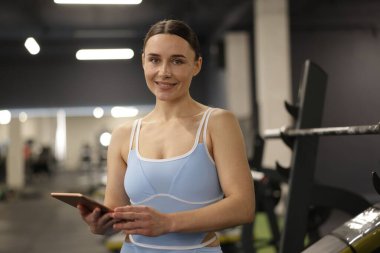 Spor salonunda tableti olan profesyonel kişisel antrenör.