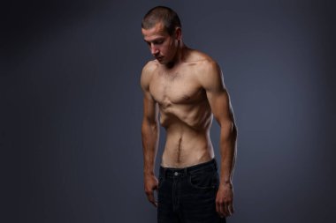 Gri arka planda iştahsızlık çeken bir adam.