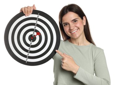 Hedef alınıyor. Gülen kadın beyaz arka planda oku olan dart tahtasına işaret ediyor.