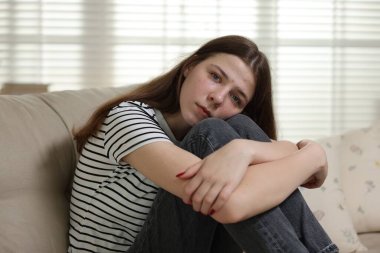 Evdeki kanepede depresif genç kız.