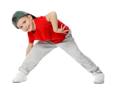 Beyzbol şapkalı küçük mutlu çocuk beyaz arka planda dans ediyor.