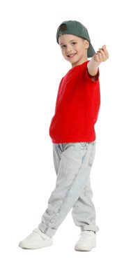 Beyzbol şapkalı küçük mutlu çocuk dans ediyor ve beyaz arka planda kalp hareketi gösteriyor.