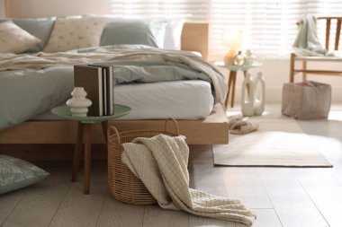 Şık bir odada yumuşak çarşafları ve dekorasyonu olan rahat bir yatak. Ev tekstili