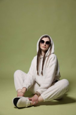 Yeşil arka planda şık giyinmiş güzel bir kadının moda portresi.