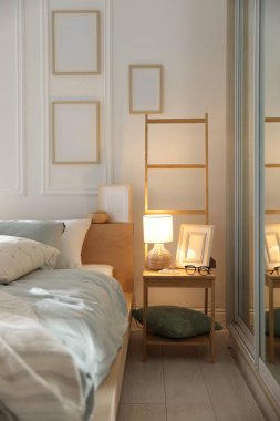 Yumuşak çarşafları, lambası ve dekoru olan rahat bir yatak. Ev tekstili