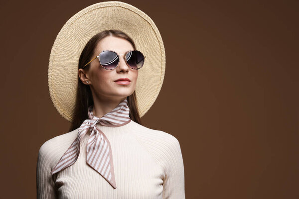 Fashionable portrait of beautiful woman in stylish outfit on brown background. Space for text