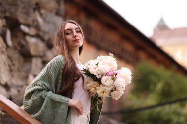 Şehir caddesinde bir buket güzel şakayığı olan çekici bir kadın. Metin için boşluk