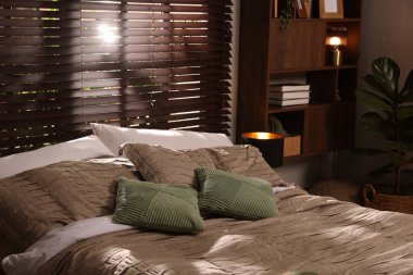 Yatak odasında güzel çarşafları olan rahat bir yatak.