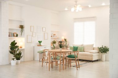 Odada rahat bir kanepe ve sandalyeli şık bir yemek masası. İç tasarım