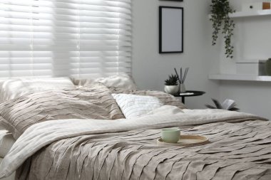 Yatak odasında güzel çarşafları olan rahat bir yatak.