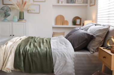 Odasında yumuşak çarşaflar ve battaniyeler olan rahat bir yatak. Ev tekstili