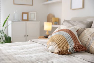 Odasında yumuşak çarşaflar olan rahat bir yatak, yakın çekim. Ev tekstili