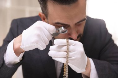 Lüks kolyeyi içeride değerlendiren, yakından gören bir eksper.