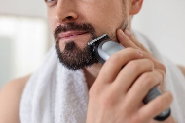 Adam tıraş makinesiyle tıraş oluyor, yakın plan.
