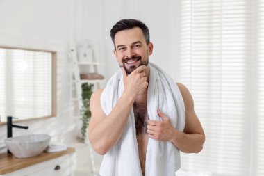 Banyoda tıraş olmadan önce gülümseyen bir adamın portresi.