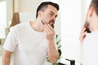 Banyoda aynaya bakmadan önce yakışıklı bir adam.