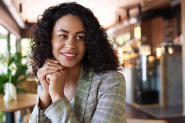 Kafedeki gülümseyen Latin Amerikalı kadının portresi.