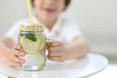 Masada limonata kavanozu olan küçük bir çocuk, seçici bir odak noktası. Tazeleyici içecek.