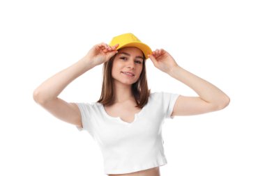 Beyaz arka planda şık sarı beysbol şapkası takan genç bir kadın.