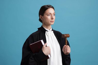 Açık mavi arkaplan üzerine kitap ve çekiçle yargıç