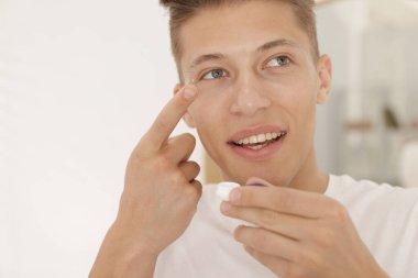 Evde kontak lens takan adam