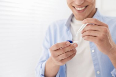 Adam kontakt lensleri evden çıkartıyor, yakın plan. Metin için boşluk