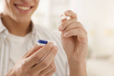 Adam kontakt lensleri evden çıkartıyor, yakın plan.