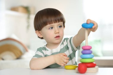 Masada oyuncak piramidiyle oynayan sevimli küçük çocuk.