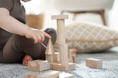 Evdeki ahşap yapı taşlarıyla oynayan sevimli küçük çocuk, yakın plan. Metin için boşluk