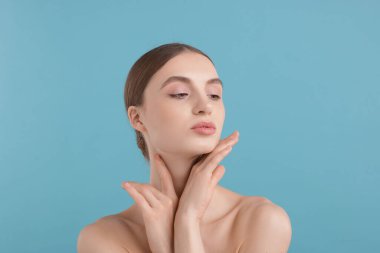 Açık mavi arka planda büyüleyici genç bir kadının portresi.