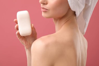 Pembe arka planda sabun barı olan kadın, yakın plan.