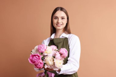 Koyu bej arka planda güzel şakayık demeti olan bir çiçekçi.