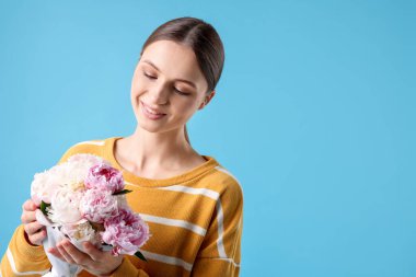Açık mavi arka planda şakayık demeti olan güzel bir kadın, mesaj için yer var.