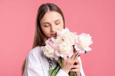 Pembe arka planda güzel şakayıklar olan bir çiçekçi.