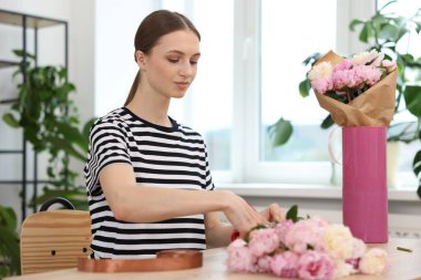 Çiçekçide şakayık buketi yapan bir çiçekçi.