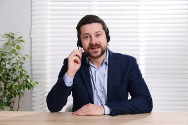 Kulaklıkla hoparlör açık oturulan masada webinar, web kamerasından görüntü