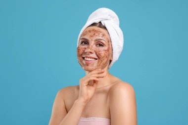 Yüzü açık mavi arka planda gülümseyen bir kadın.