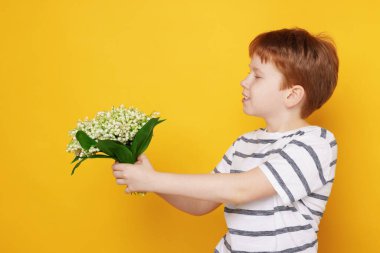 Sarı arka planda bir buket güzel çiçekli çocuk.