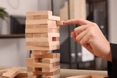 Lviv, Ukrayna - 08 Aralık 2023: Jenga oynuyorum. Masada tahta bloklar olan kule inşa eden adam, yakın plan.