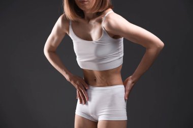 Gri arka planda iştahsızlık çeken kadın, yakın plan.