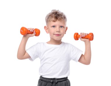 Küçük çocuk beyaz arka planda dambıllarla egzersiz yapıyor.