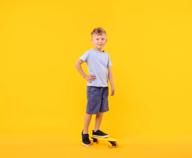 Sarı arka planda bozuk para tahtası olan küçük çocuk.