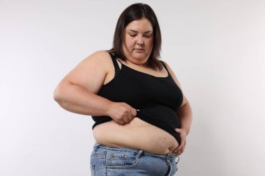 Beyaz arka planda aşırı göbek yağı olan bir kadın.